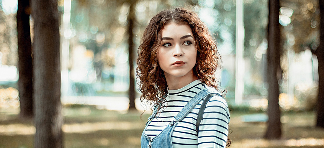 Girl in a Forrest with Brown Curly Hair