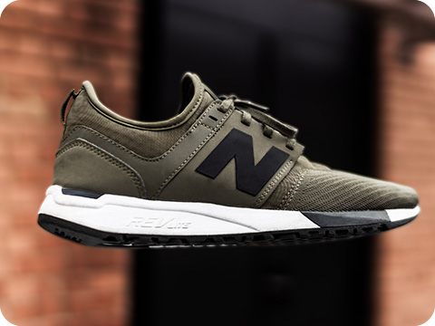 Army green running shoes from New Balance with a blurred background